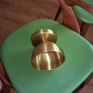 Green chair with brass light on a wooden floor